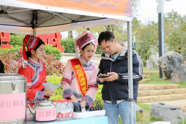 黨員們身穿民族服裝開展微笑服務(wù)。