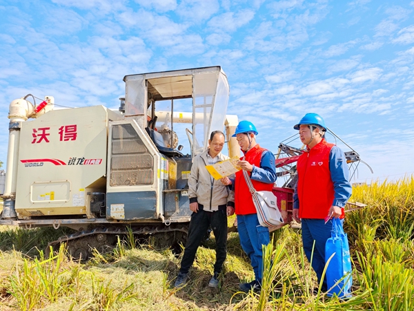 電力服務(wù)隊員向收割機司機宣傳安全用電知識，讓他們在駕駛收割機時與電力設(shè)備保持足夠的安全距離（方天學(xué)攝）.jpg