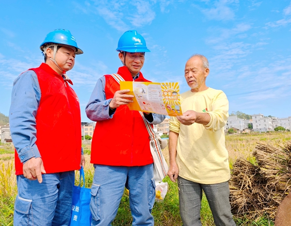 電力服務(wù)隊員向在田間勞動的群眾宣傳安全用電知識。方天學(xué)攝