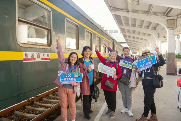 旅客在站臺上與旅游專列合影。李超宇攝