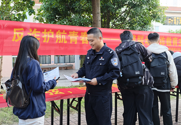 民警向同學們發(fā)放反詐宣傳手冊。