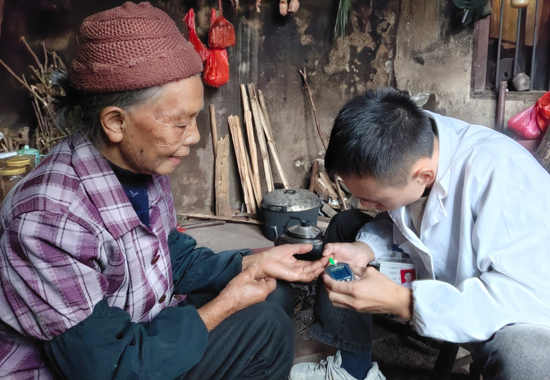 村醫(yī)唐瞻豪入戶為村民測(cè)量血糖。