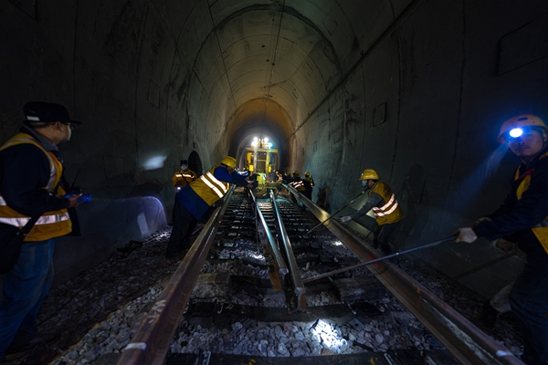 施工人員在隧道內(nèi)施工作業(yè)換軌車。黃舞杰攝