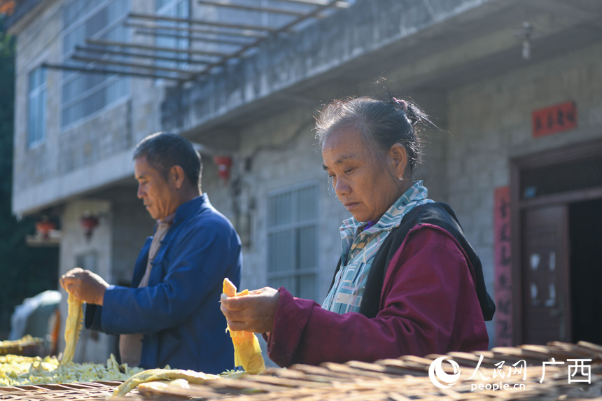 門屯村筍農(nóng)在自家門前曬筍。