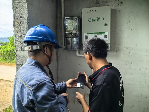 供電局工作人員正在指導(dǎo)農(nóng)戶進(jìn)行掃碼用電。方瀅文攝