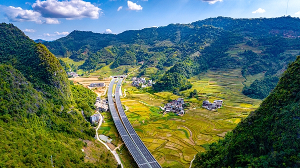 巴羌高速與綠水青山、田園村落相映成趣。