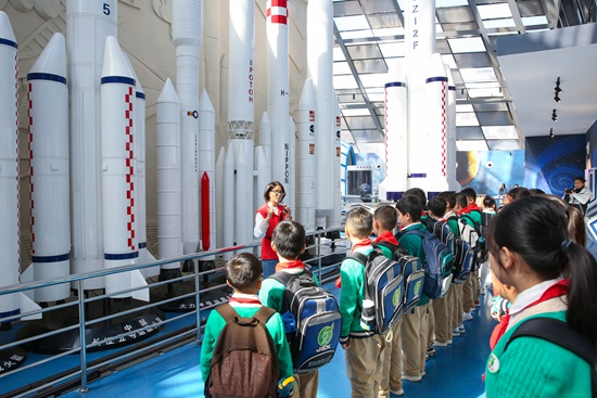 各民族少先隊(duì)員在航天世界展廳內(nèi)專注聆聽科技輔導(dǎo)員的講解。王靖山攝