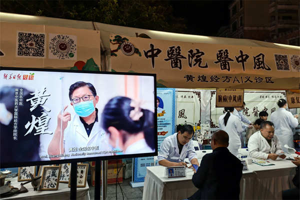 黨員醫(yī)生在中醫(yī)藥健康夜市AI義診區(qū)，通過“黃煌經(jīng)方AI輔助診療系統(tǒng)”為群眾提供智能診療服務。容縣融媒體中心供圖
