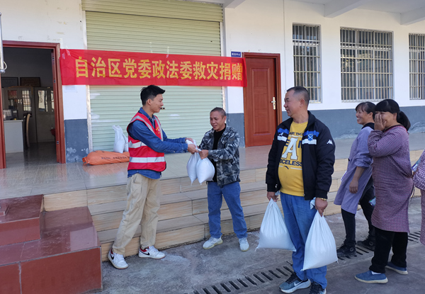 湯亮村村民排隊(duì)領(lǐng)取自治區(qū)政法委捐贈(zèng)的優(yōu)質(zhì)大米。林東婷攝