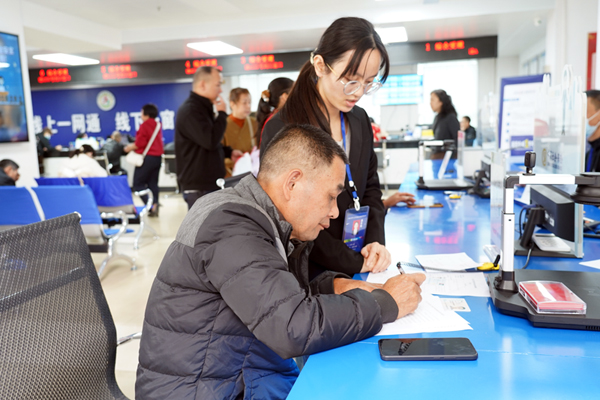 社保工作人員耐心指導(dǎo)群眾填寫申請資料。梧州市人社局供圖