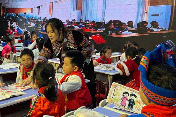 南寧市秀田小學(xué)黃佳寧老師指導(dǎo)學(xué)生欣賞民族服飾。黎秀玲攝