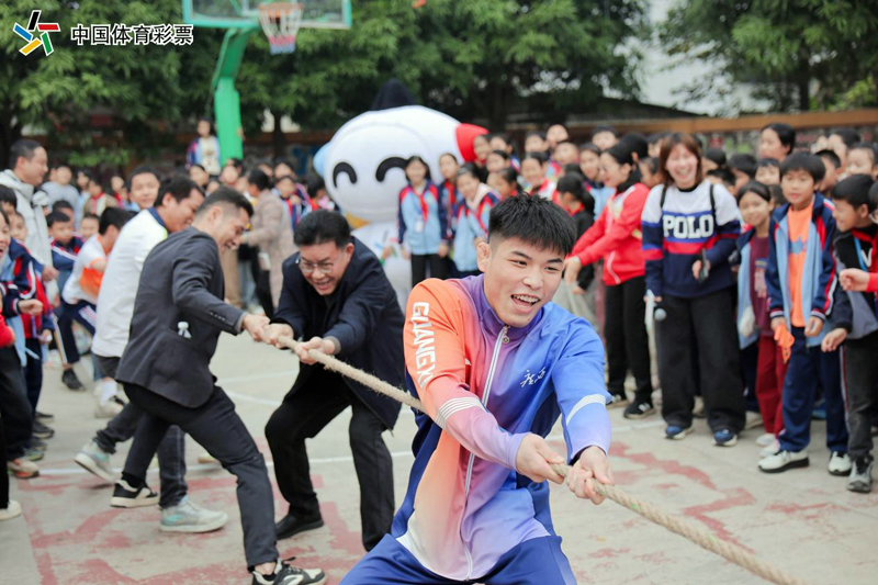 全運(yùn)會冠軍陸鋒與孩子們拔河互動。廣西體彩供圖
