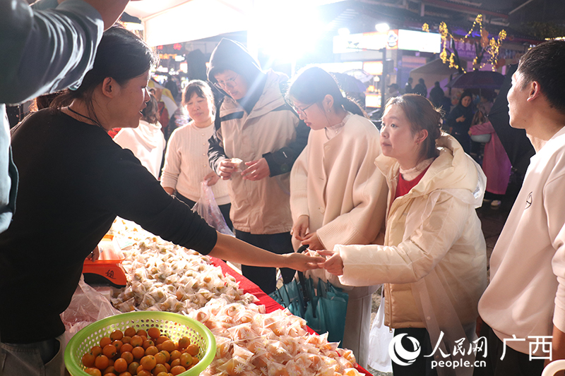 游客在活動(dòng)現(xiàn)場(chǎng)搶購(gòu)陽(yáng)朔金桔。人民網(wǎng) 劉璐瑤攝