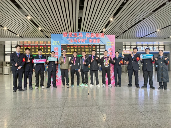 “玉馬專列”旅客與工作人員合影。曾莉攝