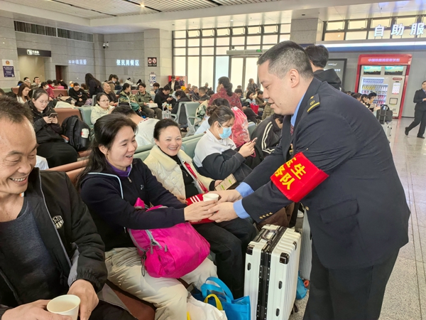 玉林站“劉玉生服務(wù)隊(duì)”隊(duì)員為專列旅客送上溫水。曾莉攝